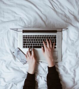 A woman's hands typing on a macbook