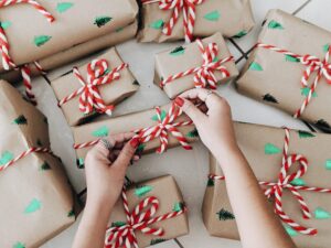 A woman tying a bow on a present