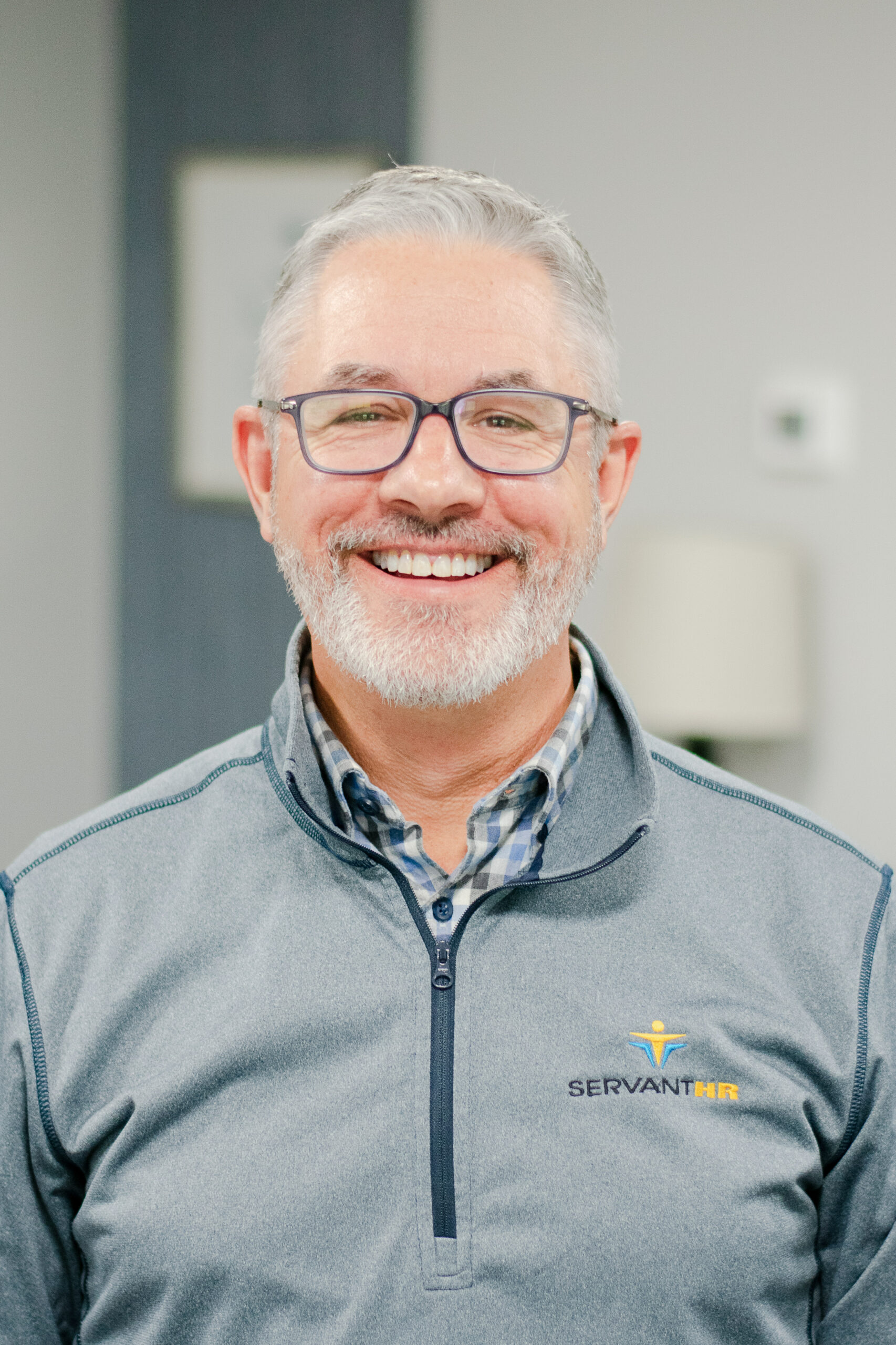 Headshot of a smiling male worker in professional attire.