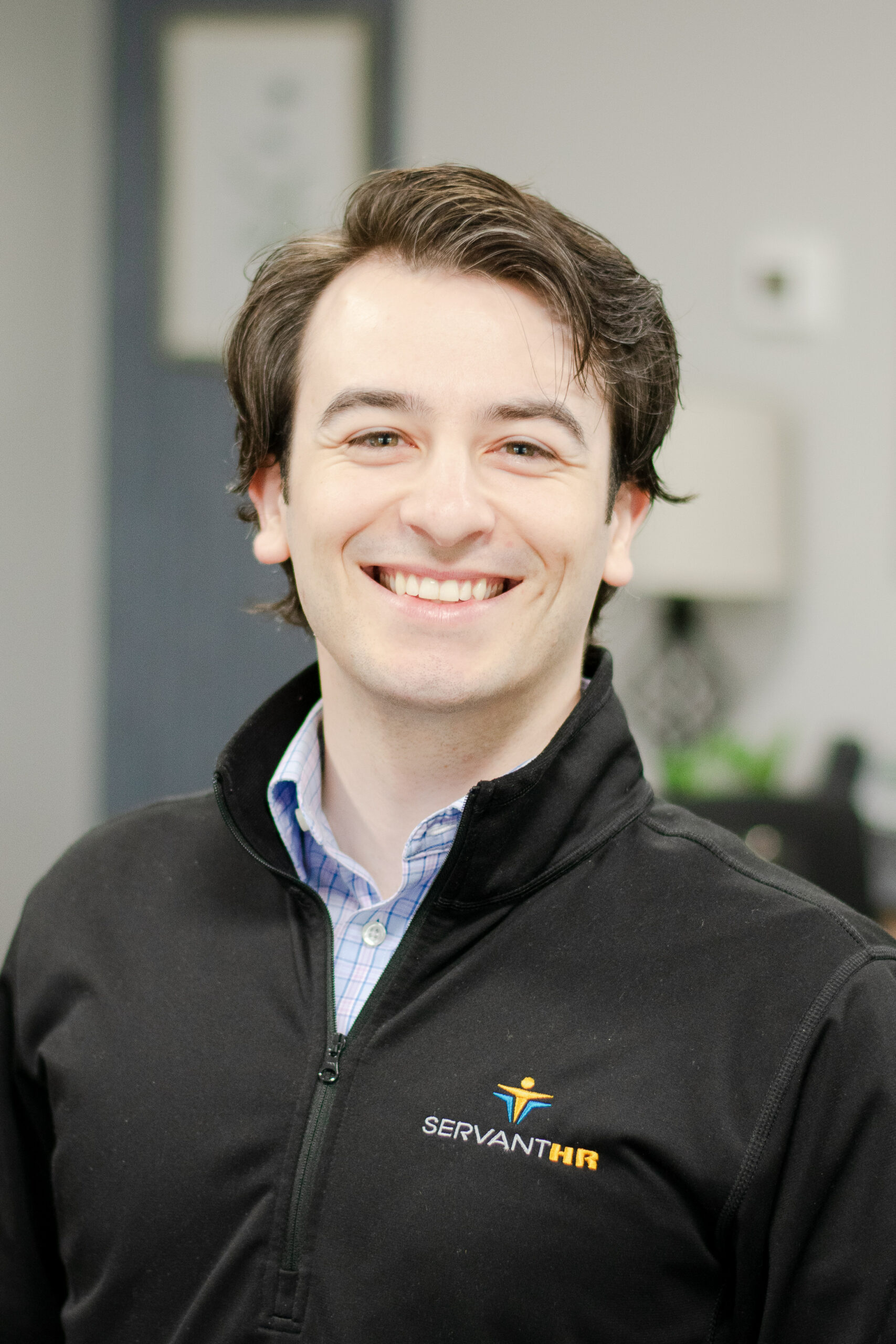 Headshot of a smiling male worker in professional attire.