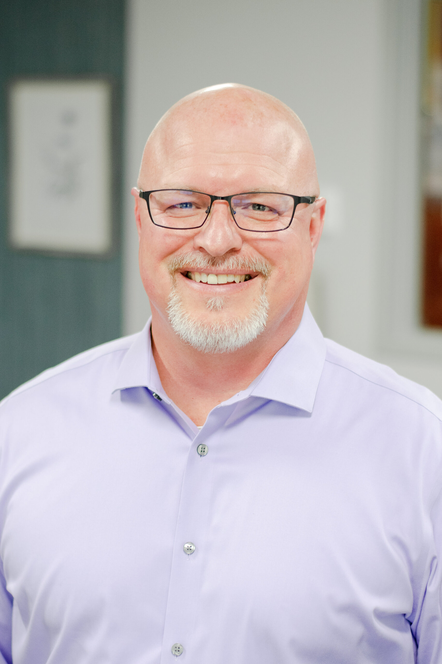 Headshot of a smiling male worker in professional attire.