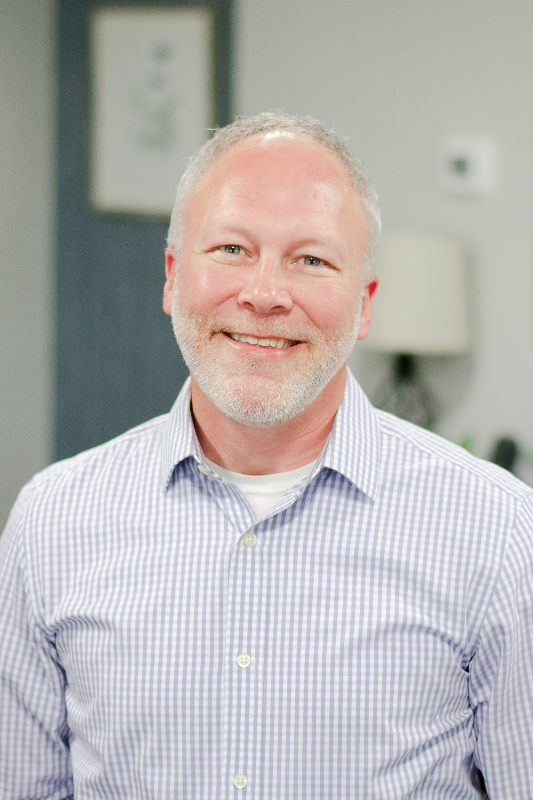 Headshot of a smiling male worker in professional attire.