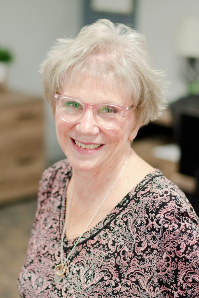 Headshot of a smiling female worker in professional attire.