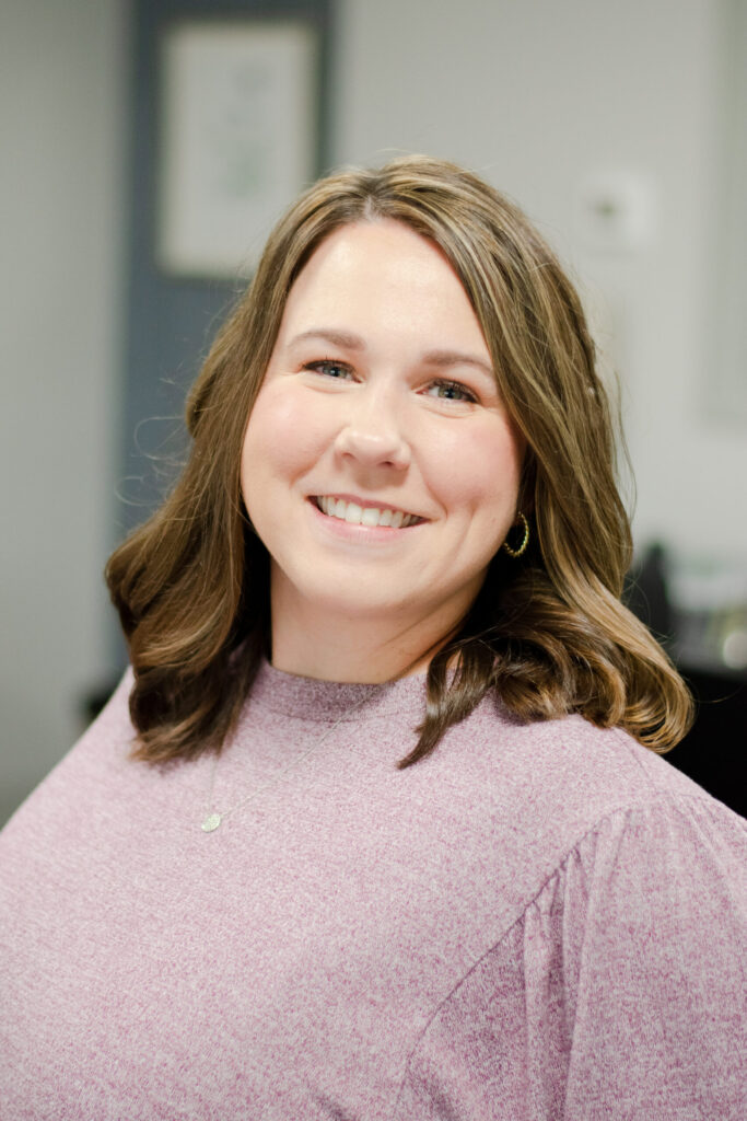 Headshot of a smiling female worker in professional attire.