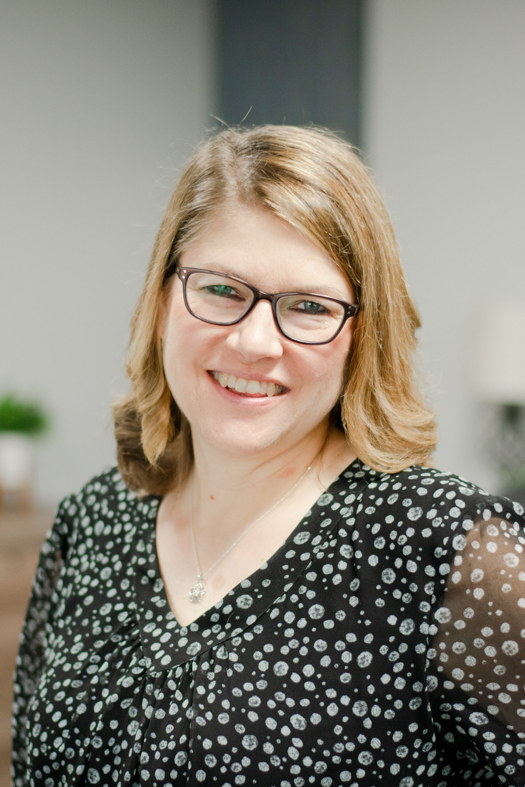 Headshot of a smiling female worker in professional attire.