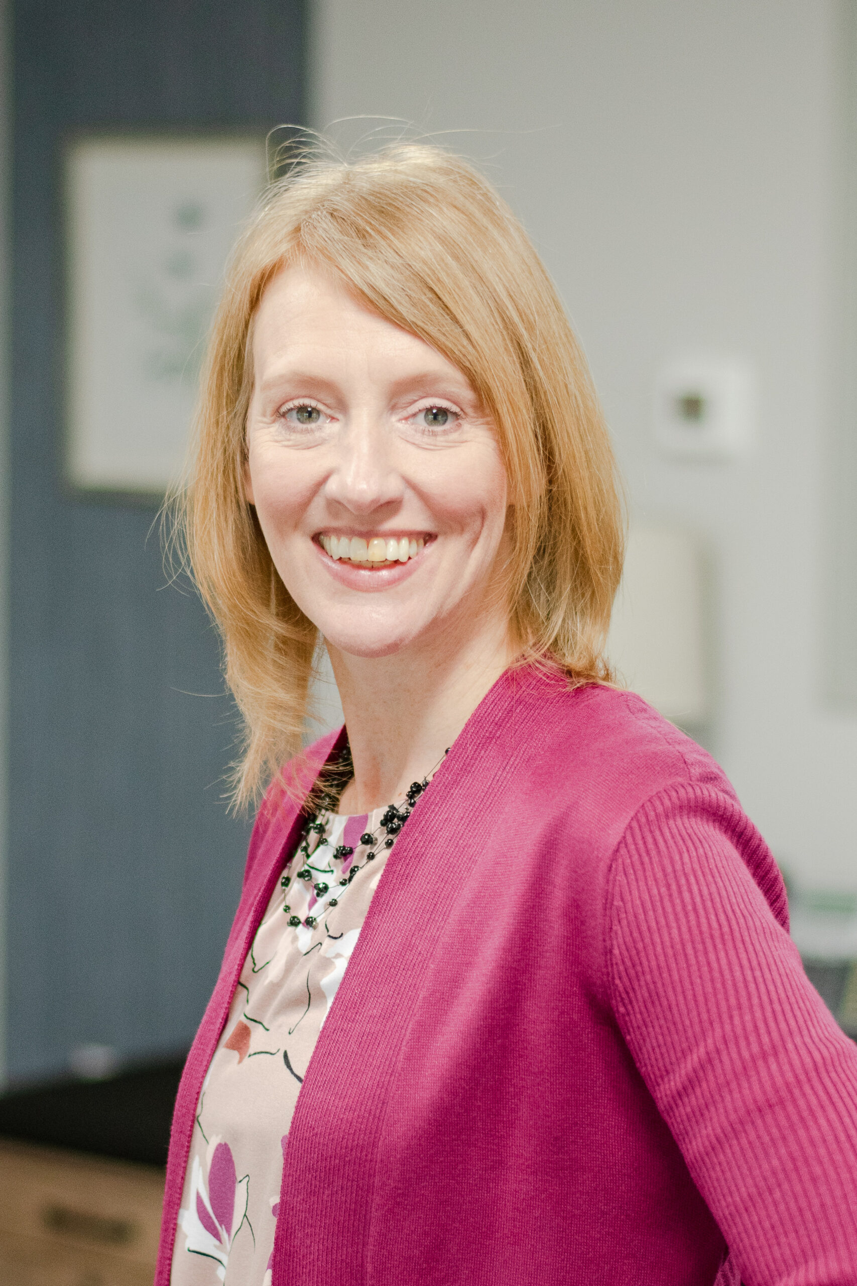 Headshot of a smiling female worker in professional attire.