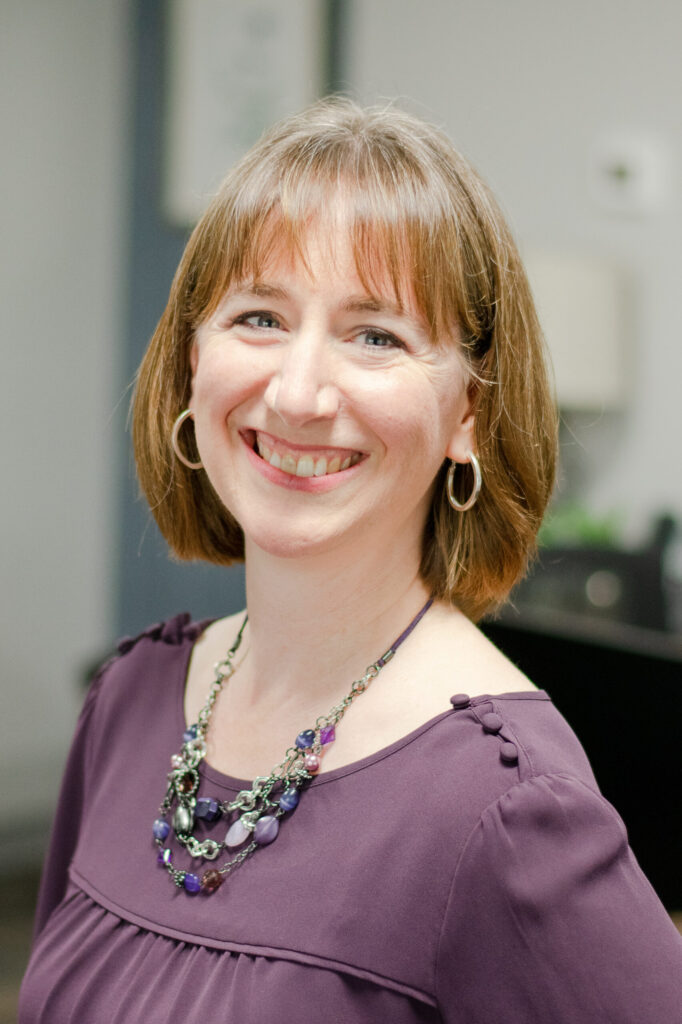 Headshot of a smiling female worker in professional attire.