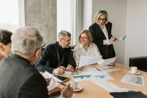 Business meeting with colleagues discussing around a conference table.